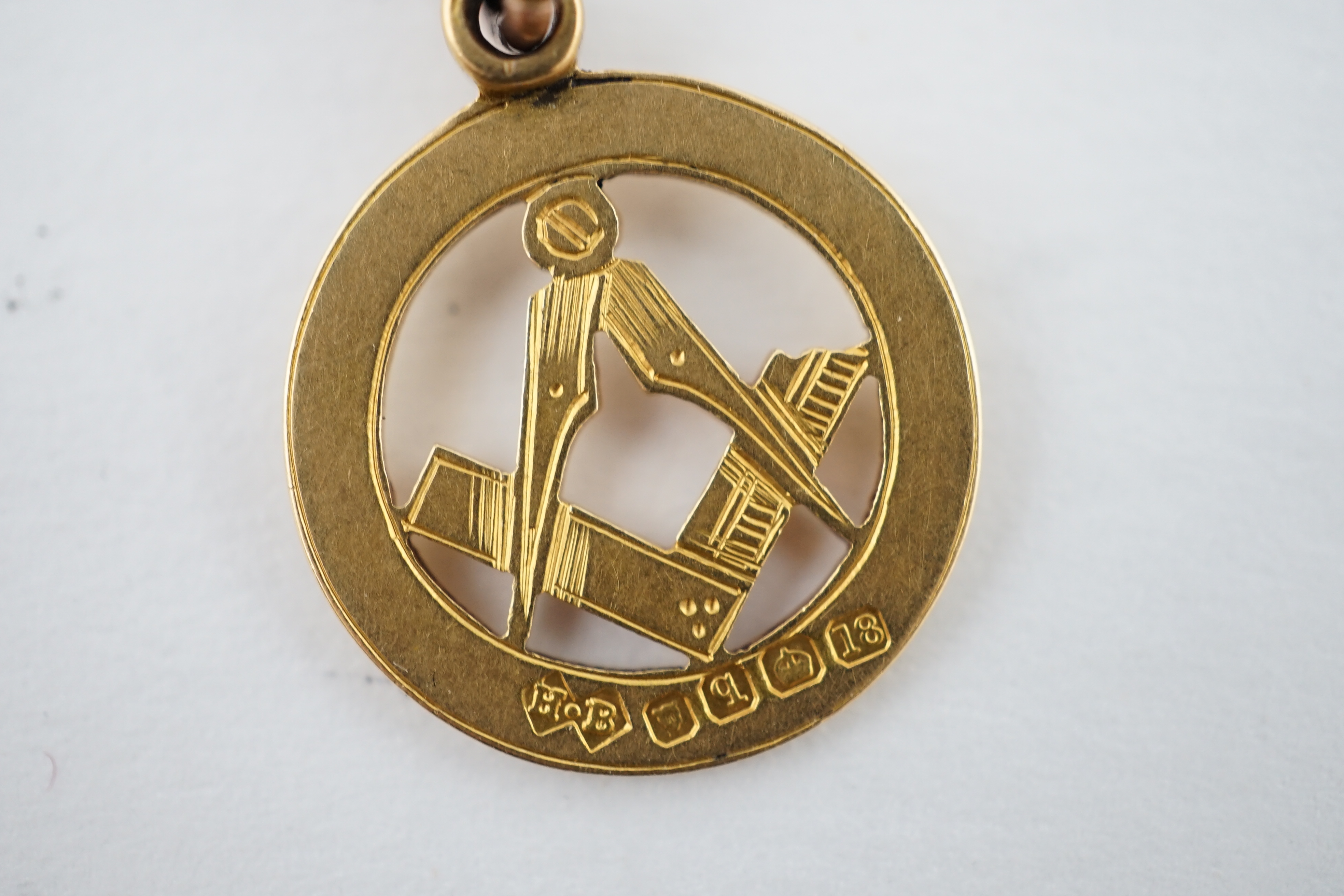 An Edwardian 9ct gold curb link albert, hung with a 9ct gold Masonic charm, locket and a double sided portrait pendant